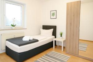 a small bedroom with a bed with a window at SUNNYHOME Monteurwohnungen und Apartments nahe Regensburg in Nittendorf +1 photo