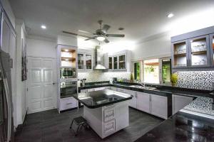 Il comprend une cuisine avec des placards blancs et un ventilateur de plafond. dans l'établissement Villa Oriole - Luxury Pool Villa, à Layan Beach