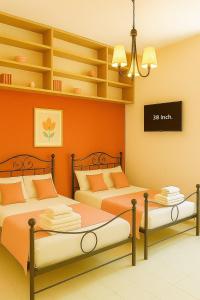 two beds in a room with orange walls and shelves at REALE COLOSSEO TREVI HOME - private garden in Rome