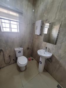 un baño con inodoro y lavabo en Danamic view hotel, en Abuja