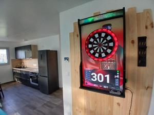 ein Fernseher mit einer Dartscheibe an der Wand in einer Küche in der Unterkunft Logement insolite avec Jeux et Jacuzzi in Soulosse-sous-Saint-Élophe