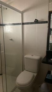 a bathroom with a toilet and a glass shower at Casa Mar in Guaratuba