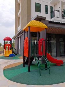 a playground in front of a building with two slides at Apartemen OSAKA Riverview PIK2 Studio By GPI in Rawalumpang