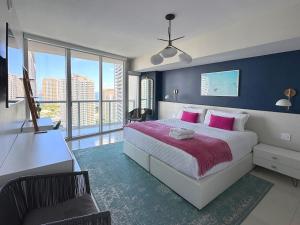 Un dormitorio con una cama grande con almohadas rosas. en Stylish 1B Icon Brickell 25th fl Pool Spa Gym Parking, en Miami