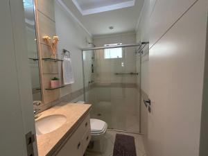 a bathroom with a shower and a toilet and a sink at Apto Almeida e Moraes 3 Suítes com churrasqueira Meia Praia in Meia Praia