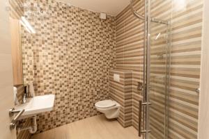 セクサールドにあるSzatmári Apartmanのシャワー、トイレ、洗面台を備えたバスルーム +16枚の写真