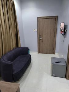 Una sala de estar con una silla azul y una puerta. en Danamic view hotel, en Abuja
