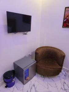 una habitación con una silla, una caja y un televisor en Danamic view hotel, en Abuja
