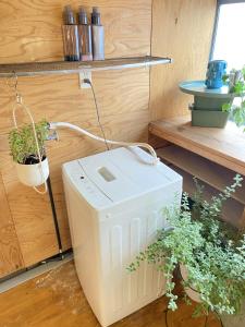 a white cooler sitting on the floor next to a plant at Takoyaki Time Osaka in Osaka