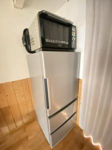 a microwave sitting on top of a refrigerator at Takoyaki Time Osaka in Osaka