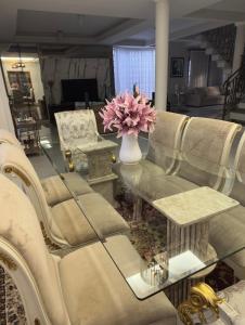 ein Wohnzimmer mit einer Couch und einem Glastisch in der Unterkunft Mansão Primavera com 03 quartos e piscina aquecida in Brasilia