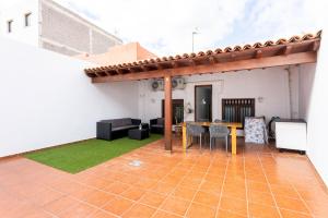 an outdoor patio with a wooden table and chairs at Home2Book Family House with Terrace in Las Maretas in La Mareta +22 photos