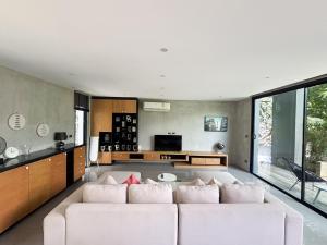 un salon avec un canapé blanc et une cuisine dans l'établissement Design Duplex Pavillion 2 BR Natural Park P11, à Kamala Beach