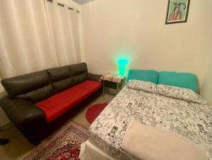 a living room with a couch and a bed at Quintal do Bueno in Goiânia