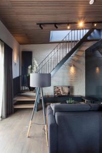 ein Wohnzimmer mit einem Sofa und einer Treppe in der Unterkunft Ilonn Boutique Limanowskiego in Posen