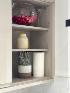 a cupboard with some food and a plant in it at Walk to Addenbrookes - Stylish 1 bed Apartment in CBG