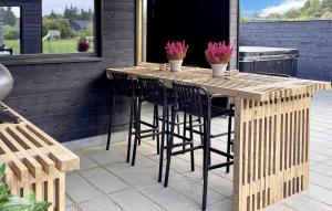 Una mesa y sillas de madera en un patio. en Awesome Home In Nørre Nebel With Sauna, en Nørre Nebel