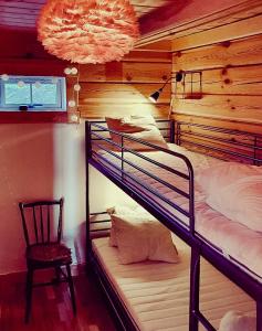 a room with two bunk beds and a chair at Mountain-Close Cabin With Panoramic View in Sälen +12 photos