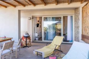 een terras met stoelen, een tafel en een raam bij Casa Mediterranio in Lumio