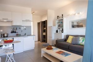 een woonkamer en keuken met een bank en een tafel bij Casa Mediterranio in Lumio