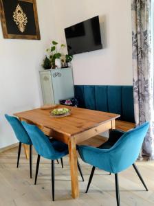 ein Esstisch mit blauen Stühlen und einem Fernseher in der Unterkunft Domek Zgredek in Żywiec