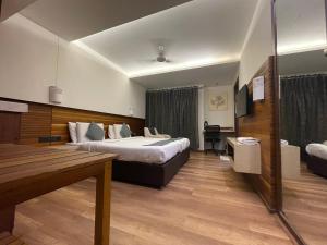 a hotel room with two beds and a desk at Hotel LOTO Premier Vijay Nagar in Jāmb