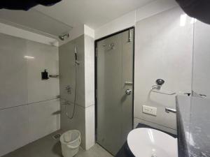 a bathroom with a shower and a toilet and a sink at Hotel LOTO Premier Vijay Nagar in Jāmb +16 photos