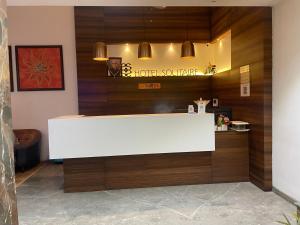 a reception desk in a hotel lobby with wood at Hotel LOTO Premier Vijay Nagar in Jāmb