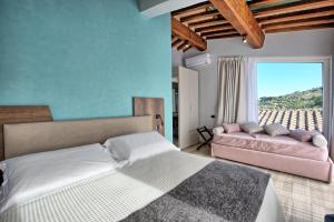 a bedroom with a bed and a couch at Villa Acquaviva with Panoramic, Private Pool and Gym - by PosarelliVillas in Panicale +63 photos