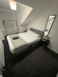 サンダーランドにあるSunderland Two Bed Apartmentsのベッドと鏡のある小さな寝室