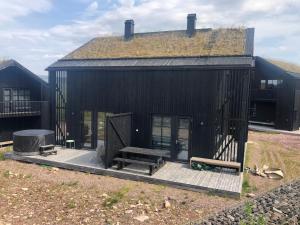 a black house with a bench and a grill at Cabin In Stöten With Stunning Natural Surroundings in Stöten