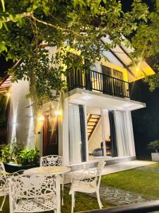 a patio with chairs and a table and a balcony at Mountain Bliss - Ingiriya in Ingiriya