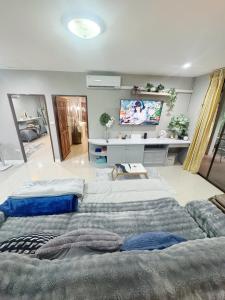 een grote kamer met 2 bedden en een televisie bij Sun and Moon House in Pattaya