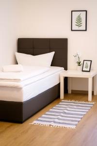 a bedroom with a bed and a side table at SUNNYHOME Monteurwohnungen und Apartments nahe Regensburg in Obertraubling