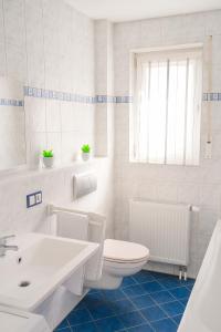 a white bathroom with a toilet and a sink at SUNNYHOME Monteurwohnungen und Apartments nahe Regensburg in Obertraubling