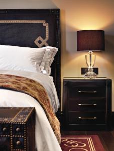 a bedroom with a bed and a lamp at Hotel Castillo de Gorraiz&Spa in Gorraiz