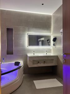 a bathroom with a tub and a sink and a bath tub at فندق دبليو سويتس القنفذة in Al Qunfudhah +23 photos