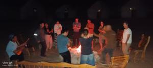 a group of people standing around a fire at Kyzylkum Nights Camp & Family Yurt in Nurota