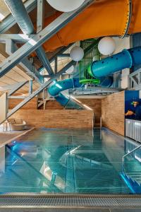 カチュベルクヘーエにあるFalkensteiner Club Funimation Katschbergの滑り台付きの建物内のスイミングプール