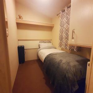 a small room with two beds and a suitcase at Lady's Mile in Dawlish Warren