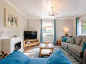 a living room with a couch and a tv at Paddock End in Great Plumstead