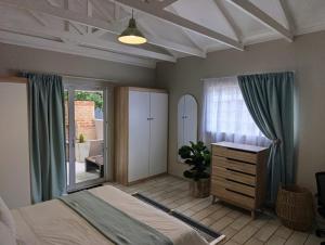 a bedroom with a bed and a dresser and a window at Joy Haven - Cottage in Centurion +20 photos