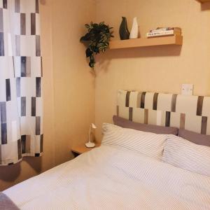 a bedroom with a bed and a plant on a shelf at Lady's Mile in Dawlish Warren
