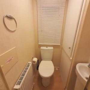 a small bathroom with a toilet and a sink at Lady's Mile in Dawlish Warren +4 photos