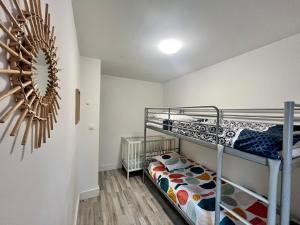 a bedroom with two bunk beds in a room at Gîte la perle rose 50 m² in Orchies