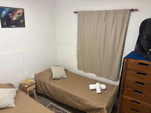a bedroom with two beds and a dresser and a window at "La Violeta" casa con jardín y cochera, San Pedro in San Pedro