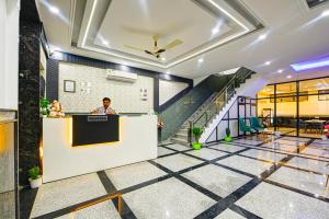 a man standing at a counter in a lobby at Airport Hotel Dream World - Offering Free Airport Drop in New Delhi