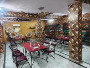 a restaurant with red tables and chairs in a room at Hotel Veeras in Palāi