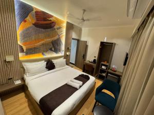 a bedroom with a large bed and a blue chair at NE Heritage Residency in Guwahati +15 photos