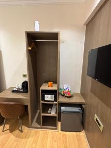a room with a closet with a desk and a tv at NE Heritage Residency in Guwahati